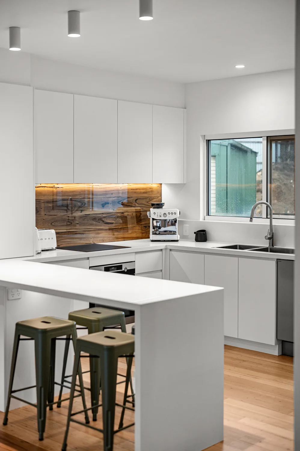 Custom kitchen with stone island bench and timber feature splashback, built in Warrnambool