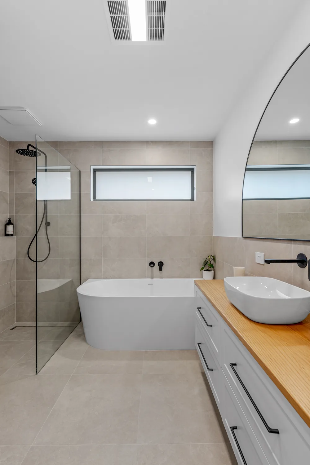 Timber vanity with vessel basin and arched mirror