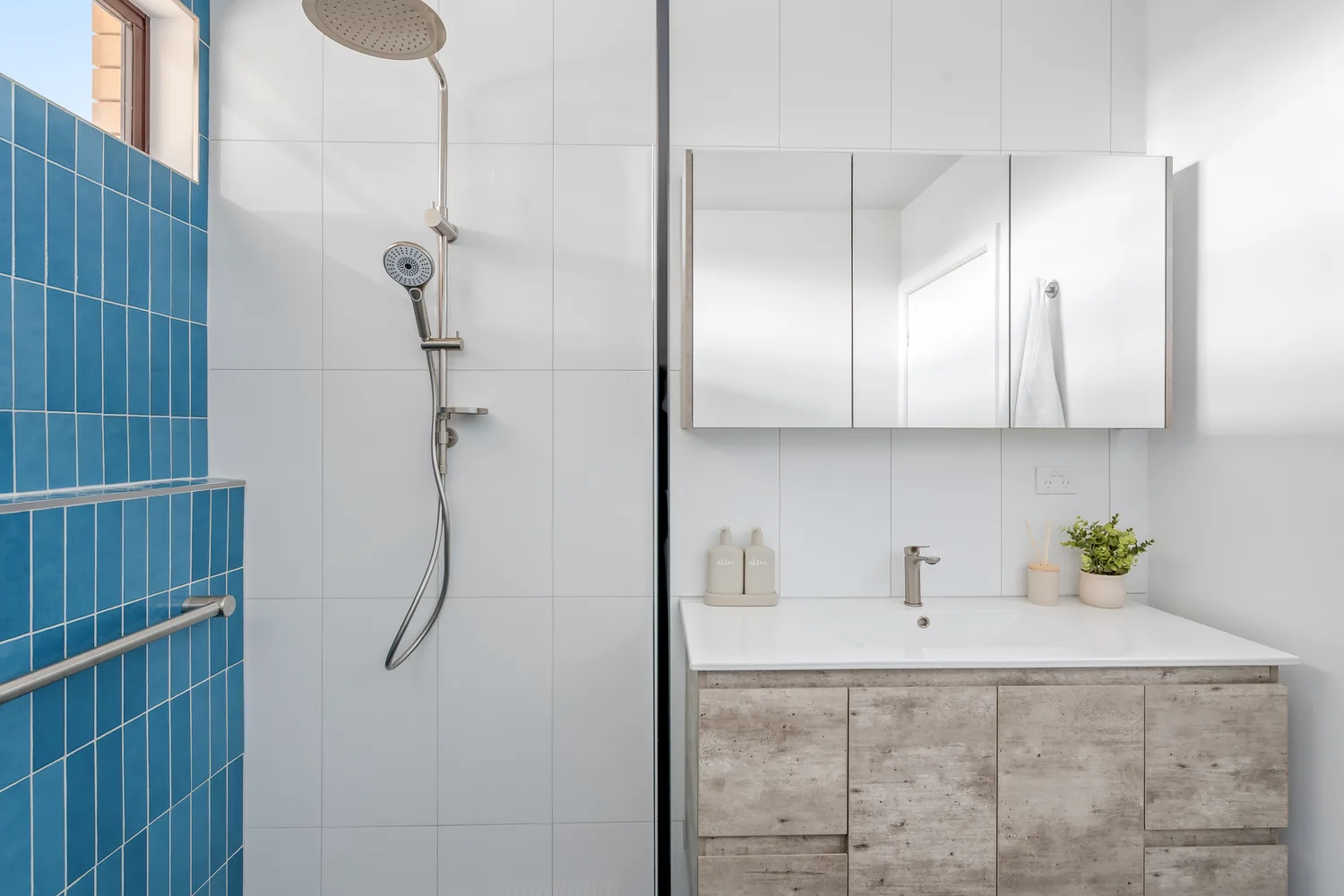 Renovated bathroom with black freestanding bath and terrazzo floor