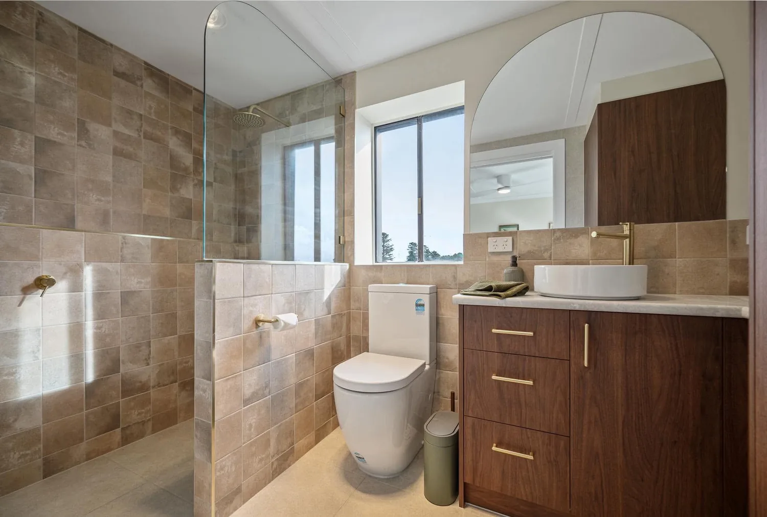 Ensuite with timber vanity, vessel basin and arched shower niche